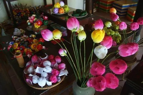 Bright handmade paper lotus flowers on a table at Thanh Tiên village