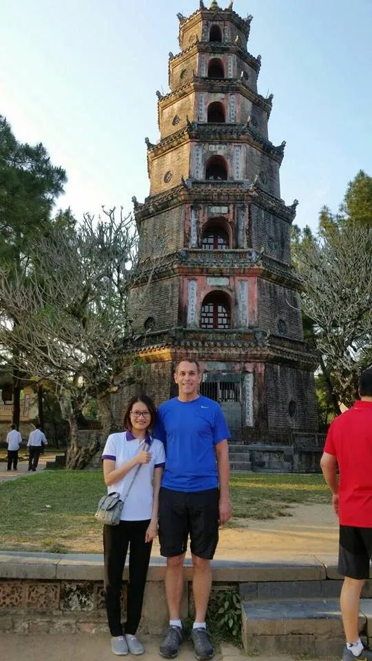 Two visitors in front of the seven-storey tower of Thiên Mụ Pagoda